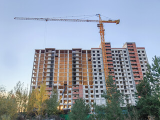 Construction of high rise residential building with tower crane in urban setting