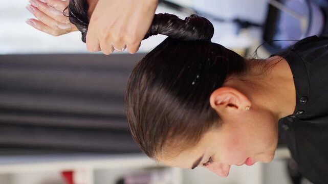 The hairdresser carefully and thoroughly wraps the hair in plait to withstand the time with the mask. High quality 4k footage