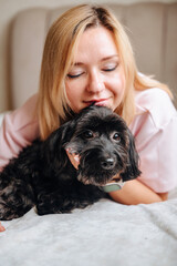 Tender moment of an owner and their dog hugging and caring for a pet in a comfortable home environment.