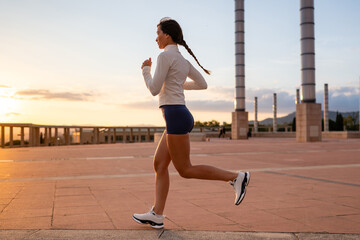 Woman running outdoors during sunset in Barcelona