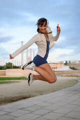 Woman jumping listening to music with headphones outside