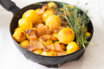 Delicious freshly cooked fried new potatoes with bacon, served in a frying pan