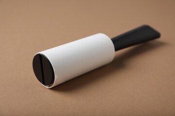 One lint roller on brown background, closeup