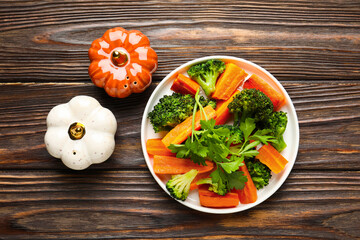 Salt, pepper shakers, vegetables and parsley on wooden table, flat lay
