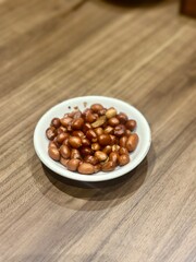 Fried peanuts served on a small white plate — a popular Indonesian snack often enjoyed as an appetizer before a main meal. October 2, 2025 - Jakarta, Indonesia