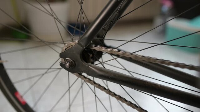 Close-up of a bicycle rear wheel spinning backward with moving chain and ratchet sound, mechanical motion and gear detail in focus