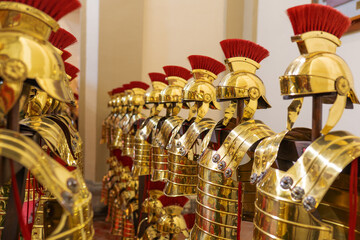 Ancient Roman legionary helmets and armor gleaming in gold, historical strength and tradition.