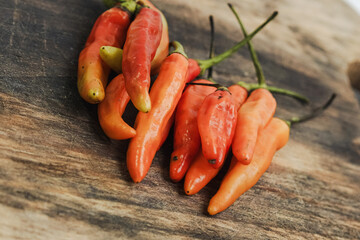 A vibrant assortment of fresh red, orange, and green chili peppers, showcasing the essential spice of many cuisines. Both close-up and scattered arrangements are captured.