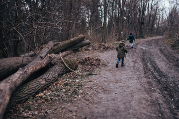 Obraz premium Children walking forest trail during moody winter