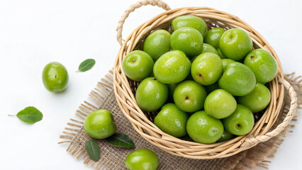 Green Jujube in wicker basket on white surface isolated on white background Top View