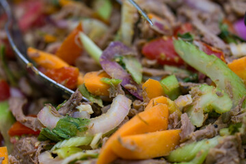 Fresh mixed salads on display at deli counter in a busy rotisserie shop for takeaway