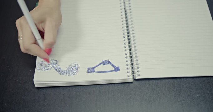 Watch as a hand sketches abstract patterns in a notebook, with the crisp sounds of pen on paper creating an immersive auditory experience. Perfect for creative, study, or work-related content.