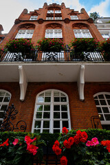 London - 06 25 2022: Facade of a brick building with flowers in Kensington Ct