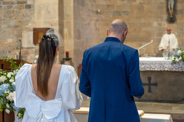 Elegant couple exchanging vows at the altar, surrounded by family and friends on their wedding day