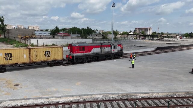 Aerial 4K drone footage of reach stackers handling shipping containers at a modern container terminal. Industrial port operations, cargo loading and unloading, logistics and transportation process in 