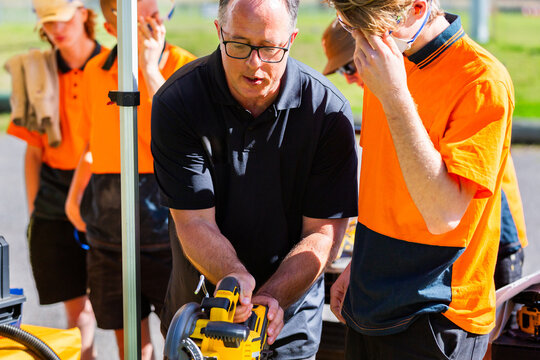 tool demonstrator teaching class of trade apprentices how to use tools
