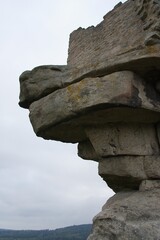 Rock formation resembling a face overlooking a forest landscape