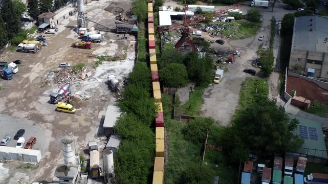 Aerial 4K drone footage of reach stackers handling shipping containers at a modern container terminal. Industrial port operations, cargo loading and unloading, logistics and transportation process in 