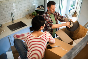 Young couple unpacking in new kitchen
