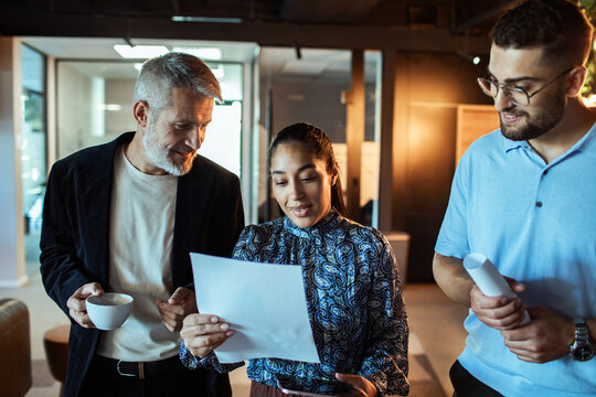 Business team reviewing documents in a hallway of an office building