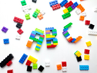 Childrens building blocks construction, red. multi-colored children's plastic constructor on a white isolated background. Kids playing learning ABC alphabet 