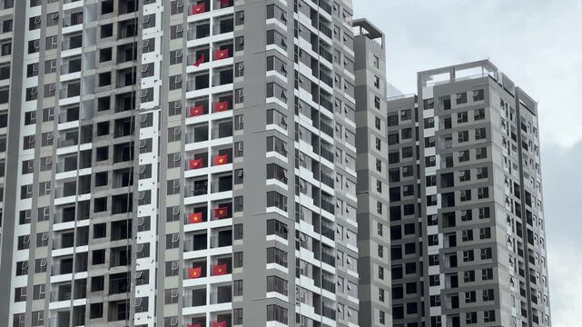 Modern high-rise construction site with Vietnam flags and cranes in daylight