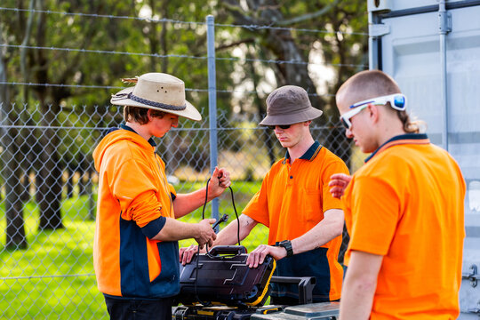trade apprentices working together to pack up tools at worksite during hands on learning course