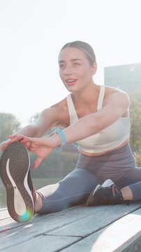 Woman stretching leg in the city park for fitness, health and wellness before a run. Exercise, sports and female athlete warm up training outside or in nature for mobility, flexibility and strength.