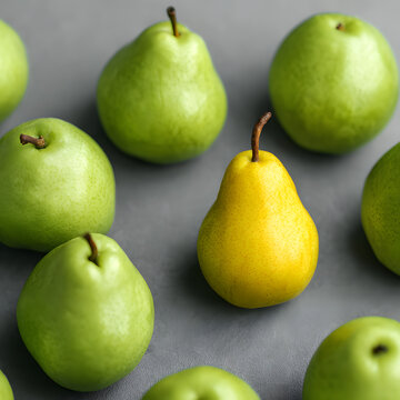 One yellow pear standing out in a group of green pears on a grey background. Minimal food concept.