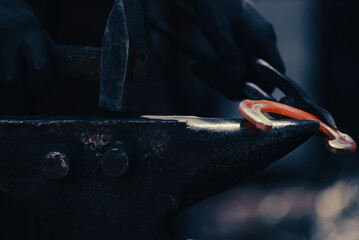 A closeup captures one heated horseshoe, red and glowing, held in the smith’s hand. The iron hammer strikes with force, echoing ancient industry in a metal manufactory shaped by timeless craft.