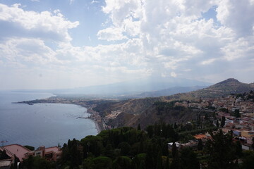 Panoramic view of the Sicilian coast, the bay of Giardini Naxos, and the majestic Mount Etna volcano, seen from Taormina, Italy