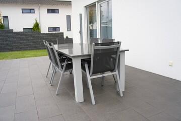 Modern patio furniture set on paving in backyard