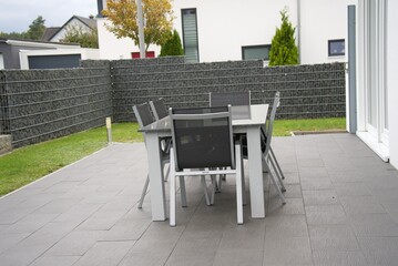 Modern patio furniture set on paving in backyard