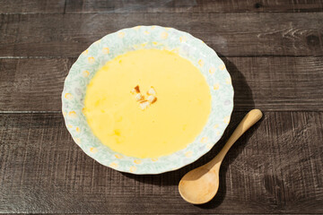 木製テーブルに置かれたコーンスープ