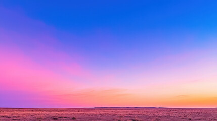 Fototapeta premium Stunning landscape featuring vibrant sunset sky with shades of pink, purple, and blue over vast desert terrain, evoking sense of tranquility
