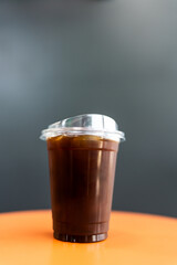 A glass of ice americano coffee placed on wood table in cafe