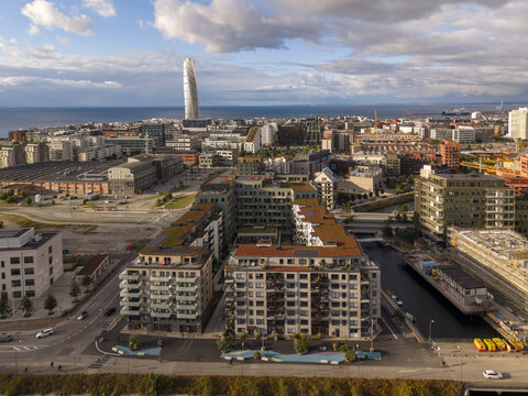 Aerial view of the Turning Torso skyscraper piercing the skyline above the city's modern architecture and waterways, Malmo, Scania County, Sweden.