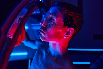 Tall alien in a vibrant science lab engaged in a futuristic experiment
