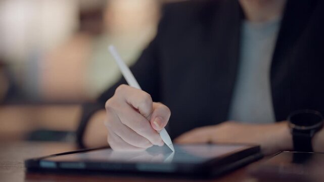 Close up hand of woman using stylus pen on tablet screen for online education or digital learning.