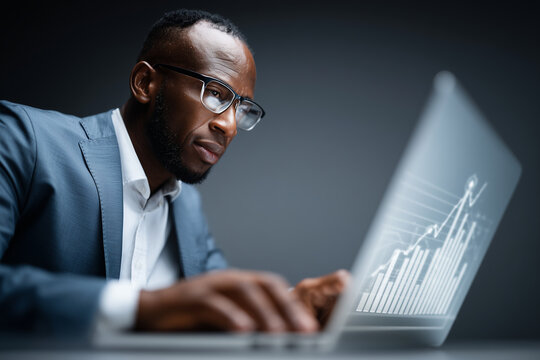 Professional man using laptop with holographic business graphs