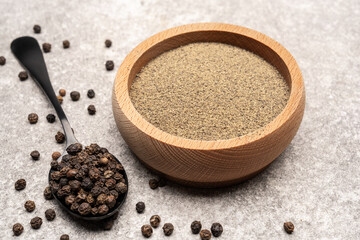  Black peppercorns on white stone table background