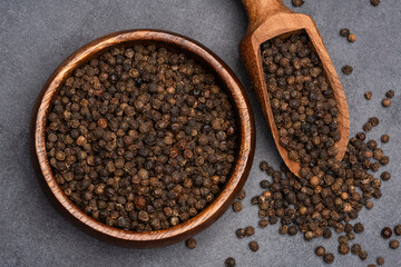 Black peppercorns on black stone table  background