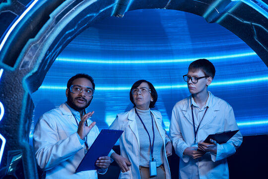 Scientists explore alien technology in a futuristic lab environment with holographic displays