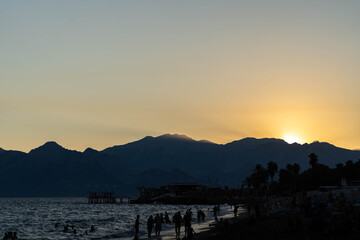 Sunset Beach View with People Walking Along the Shore