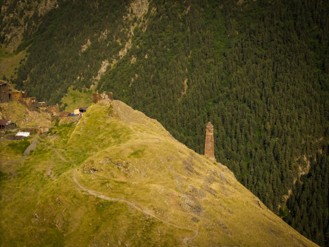Aerial view of ancient stone watchtowers pierce the sky atop rolling green hills, nestled near the village, Dartlo, Kakheti, Georgia.