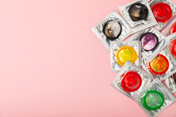 Condoms on a colored background. Colorful fruit-themed condoms in packaging. Safe sex concept....