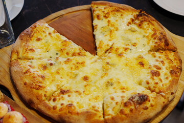 Delicious freshly baked cheese pizza served on a wooden board