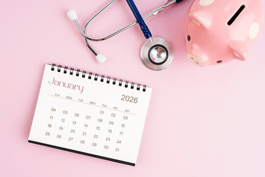 January 2026 desk calendar and stethoscope with piggy bank, Savings for health concepts.