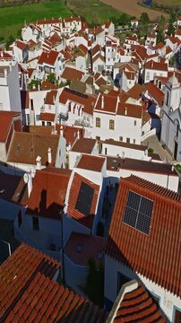  Aerial view of small village with windmill and picturesque rooftops, Odeceixe, Portugal