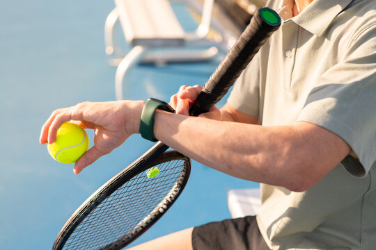 asian man checking his fitness smartwatch at tennis